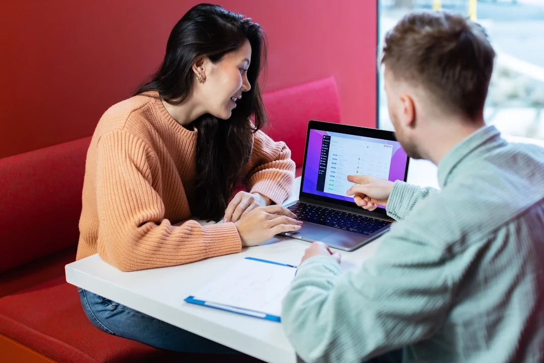 Two people engaging in online education via a laptop, perfect for illustrating virtual learning.
